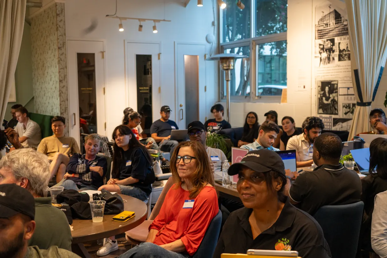 A packed room at the Claude Impact Lab in Atlanta, attendees seated and turned toward the front during the pitch block.