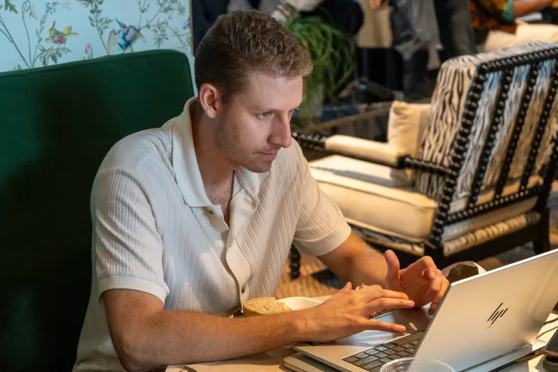 An attendee working on a laptop at a table.
