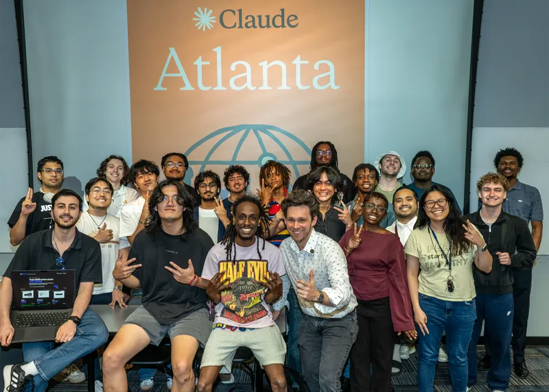 Workshop attendees gathered for a group photo in front of the Claude Atlanta banner